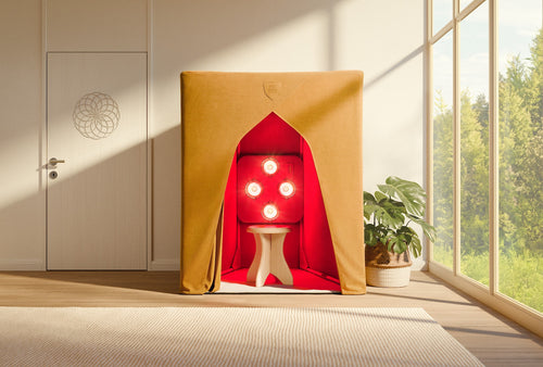 The SaunaSpace FireLight Infrared - Classic, a fabric-covered booth with a red interior and four circular lights offering EMF protection, stands by a window and plant in a bright, modern room.
