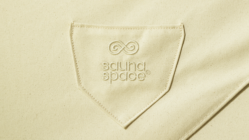 Close-up of top of GOTS-certified organic cotton Sauna Cover of the FireLight Infrared Sauna, showing SaunaSpace logo embroidered on front pocket