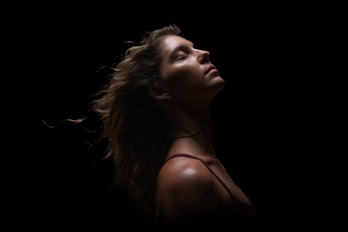 Woman with eyes closed and hair blown behind her
