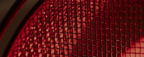 Close-up of stainless steel bulb guard on SaunaSpace light panels with FireLight bulb on