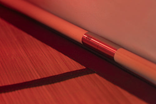Close-up of a basswood sauna frame pole with stainless steel pole connector above Bamboo Grounding mat of  FireLight Infrared Sauna