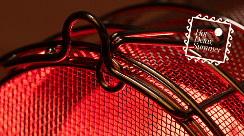 Close up of SaunaSpace FireLight Stainless Steel Bulb Guard on a dark background, featuring 'Hot Detox Summer' logo.