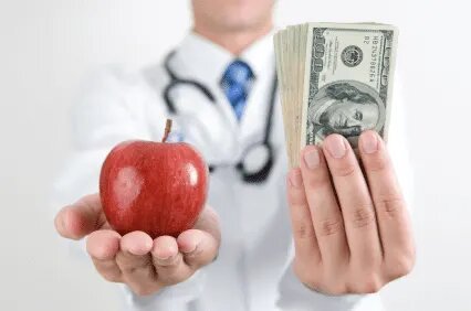 doctor holding apple in right hand and cash in left hand