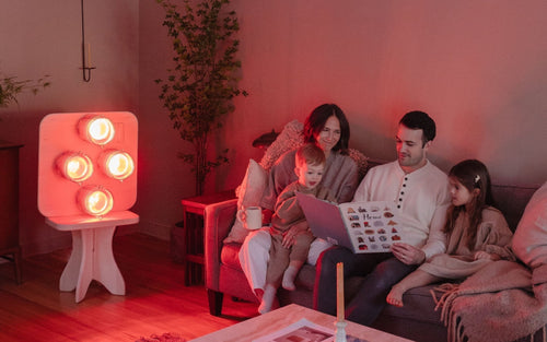 A modern living room bathed in soft red-gold infrared light, evoking the warmth and intimacy of a traditional fireplace, without smoke, firewood, or pollution.