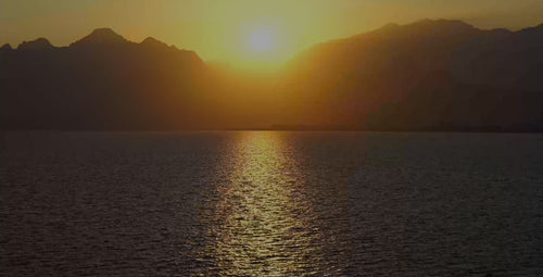 Sun setting in mountains above lake