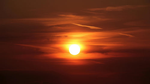 Sun setting in cloudy sky