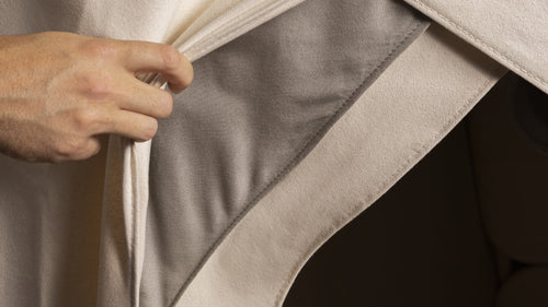 Close-up of a hand pulling back outer cover at entrance of FireLIght Infrared Sauna, revealing hidden EMF-blocking SilverLining cover