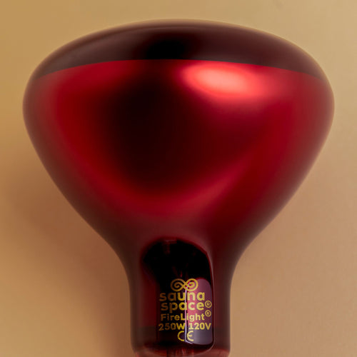 SaunaSpace FireLight Red and Infrared Therapy Bulb – deep red-tinted glass bulb photographed from an angled top-down view, showcasing its smooth, rounded design and radiant finish.