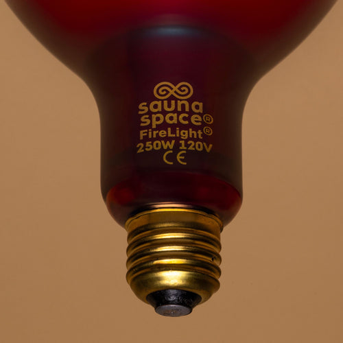 Close-up of the SaunaSpace FireLight Red and Infrared Therapy Bulb base – showing gold screw-in socket and clear product labeling: 250W 120V CE certified.