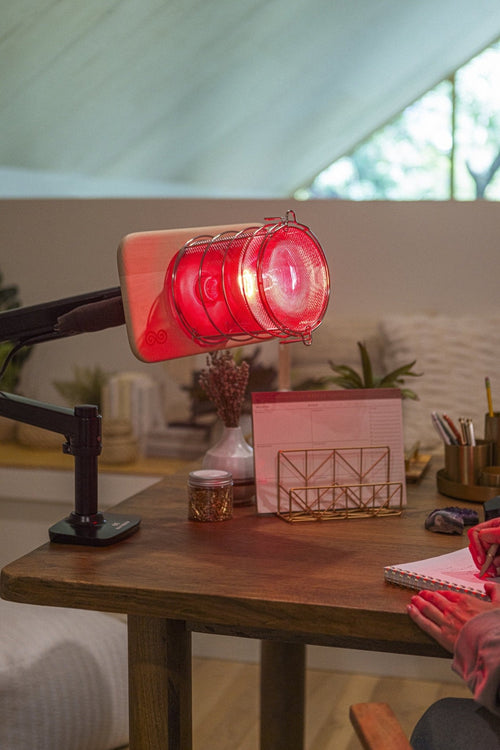 SaunaSpace Glow Desk Arm mounted on desk with Glow Infrared Therapy Light installed