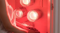 Woman in closet in front of Hearth Quartet Infrared Sauna Panel with lights on