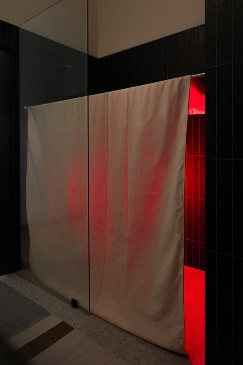 Shower Sauna Conversion Kit - canvas shower curtain closed, installed in walk-in bath shower with black tiles and red light inside