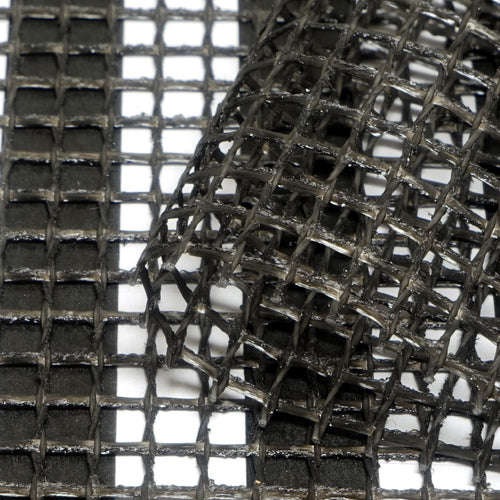 Close-up of ARM40 - 50m roll by Shielded Healing: black stainless steel wire mesh grid with a section lifted, highlighting its interwoven metal strip texture against a white background.